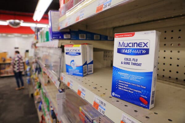 Boxes of Mucinex on a pharmacy store shelf.