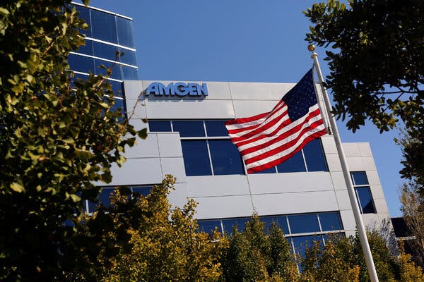 An exterior view of Amgen's company offices in South San Francisco on a bright day. An American flag waves outside.