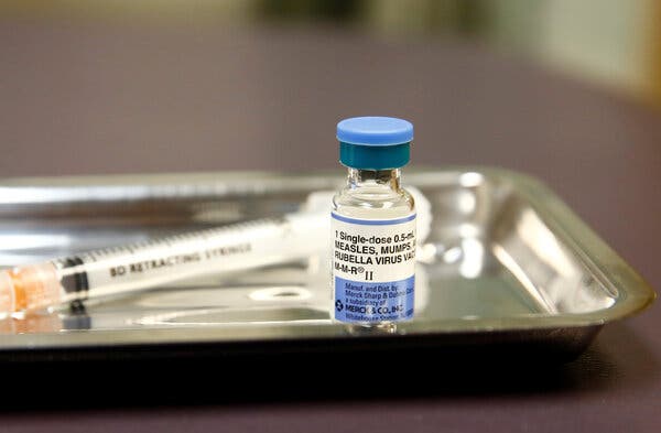 A vial of a measles, mumps and rubella vaccine in a tray on a table in a clinic.