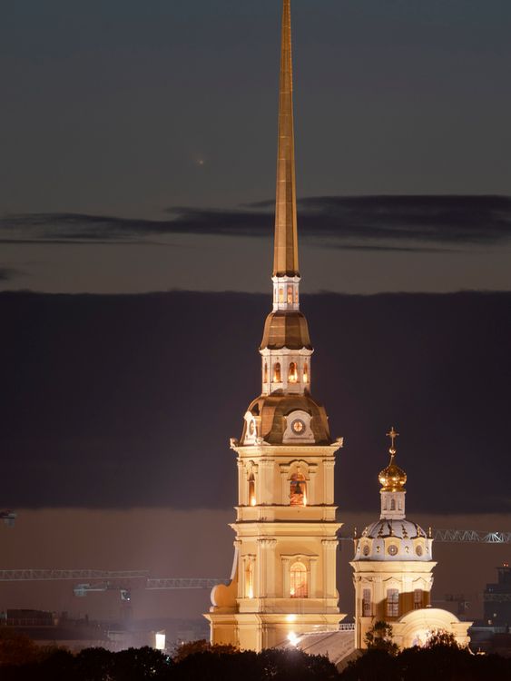 The C/2023 A3 (Tsuchinshan...ATLAS) Comet is visible left from the spire of the Saints Peter and Paul Cathedral after sunset in St. Petersburg, Russia, Saturday, Oct. 12, 2024. (AP Photo/Dmitri Lovetsky)