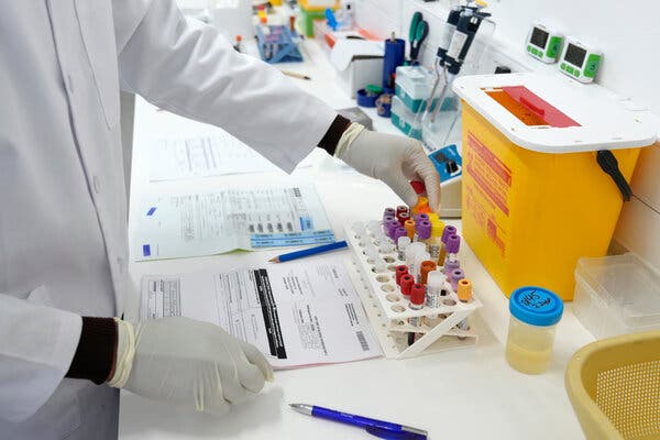 A lab technician works with vials of H.I.V. prevention drugs in a lab.