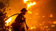 A firefighter battles the Hughes Fire near Castaic Lake