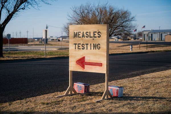 21hs-measles-top-pqhb-articlelarge “Measles Testing” is spray painted onto a plywood sign, with a red arrow, by a street in Seminole, Texas.