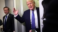 Donald Trump speaks to reporters, watched by National Security Advisor Mike Waltz, aboard Air Force One.
Pic: Reuters